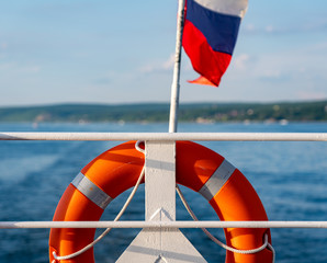 Russian flag tricolor together with a life buoy on a water vessel as a concept of rescue and the...