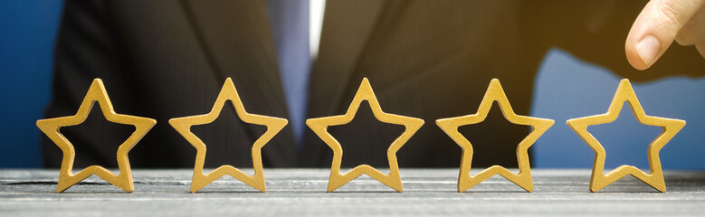 Businessman points to the fifth star. The concept of the rating of hotels and restaurants. The...