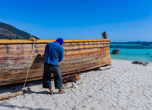 One man fixing a fishing boat