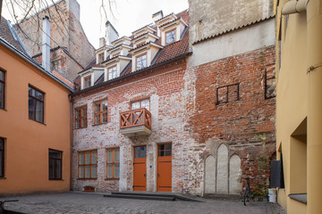 Tourism in Europe. Old town in Riga, Latvia. Brick old building with balcony. Modern architecture.