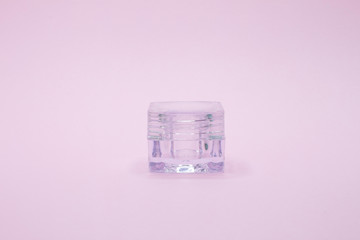 Empty cosmetic jar on pink background