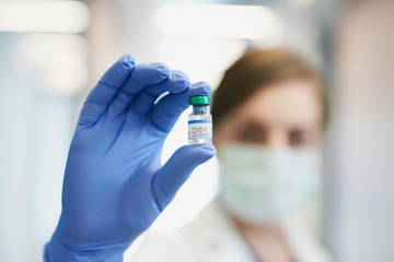 Ampule with coronavirus held by a doctor