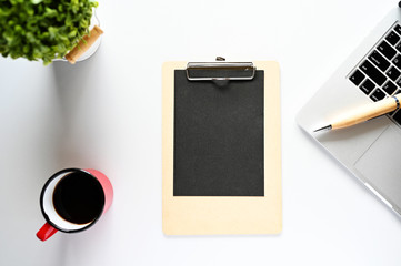 Blank paper on the clipboard With laptops and coffee On the morning office desk