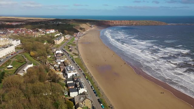 Aerial footage of the British seaside town of Filey, the seaside coastal town is located in East Yorkshire in the North Sea coast showing the beach and ocean.
