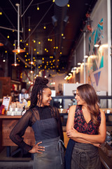 Two Female Coffee Shop Owners Standing At Sales Desk