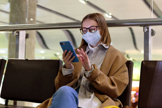 Woman upset over flight cancellation, writes message to family, sitting in almost empty airport terminal due to coronavirus pandemic/Covid-19 outbreak travel restrictions. Quarantine measure