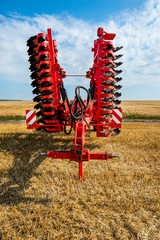 Red harrow folded for transportation for cultivating the land.