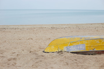 an old yellow boat on sea coast