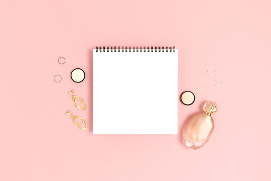 Female accessories and cosmetics on a pink pastel background. Open notepad mockup. Fashion concept with copy space.