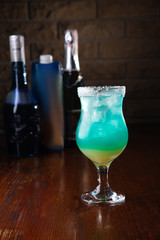 Refreshing sea blue cocktail on a wooden background
