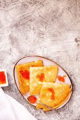 Fototapeta na wymiar Traditional Russian pancakes with red caviar. Fried crepes with caviar and sour cream