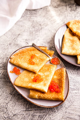 Traditional Russian pancakes with red caviar. Fried crepes with caviar and sour cream