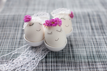 Easter decoration, white eggs with wreaths on a light gray background