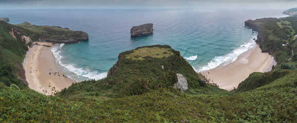 Paisaje de la costa de Asturias con sus playas y montaña verde.