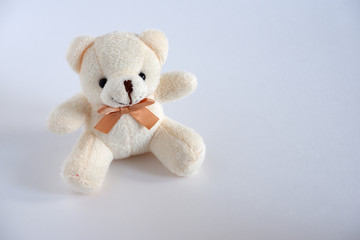 A soft beige bear is sitting there. Children's toy