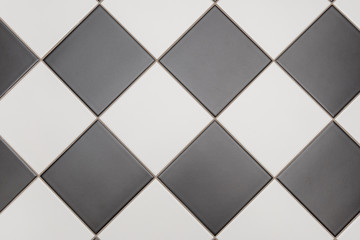 Bathroom tiles in black and white laid out in diamond pattern