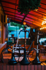 Fototapeta na wymiar Stylish wooden hookah in the evening on a summer terrace in a cafe