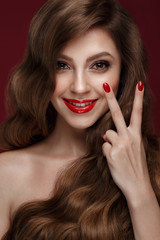Beautiful girl with a classic make up, curls hair and red nails. Manicure design. Beauty face.
