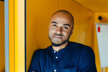 Obraz premium Happy african american businessman entrepreneur startup owner stand in modern office looking at camera, smiling young black designer creative person posing in work space
