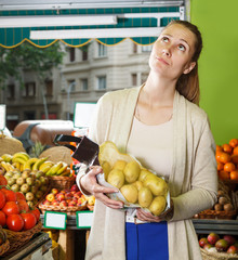 Obraz premium Smiling woman is standing with potatos