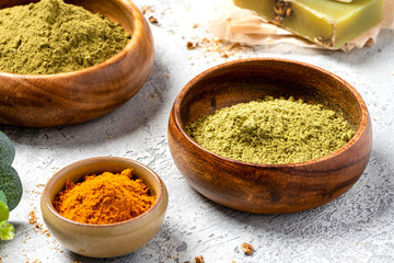 Ayurvedic hair care products. Henna, turmeric and neem powder in bowls on a grey background. Natural care and hair coloring.	