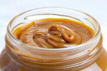 Closeup of jar full of milk caramel spread or dulce de leche