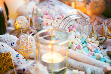 christmas marshmallow glass jar on textile with candle