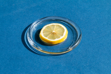 Lemon isolated on blue background, natural sunlight with hard shadows. Healthy eating concept