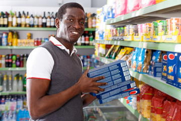 African man buying pasta in supermarket
