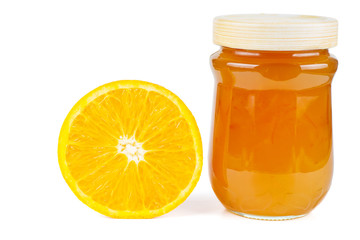 Homemade orange jam in glass jar and half orange isolated on white background
