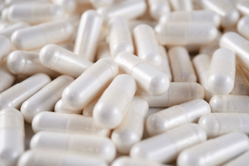 Closeup of a pile of white medicine capsules