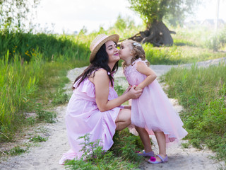 Naklejka premium beautiful mother and daughter outdoors hugging in nature