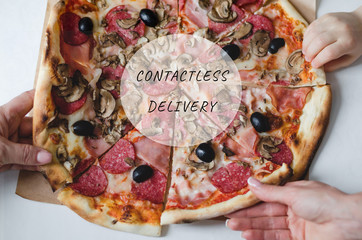 Pizza in a box and the inscription contactless delivery. Delivery of the product during quarantine. 