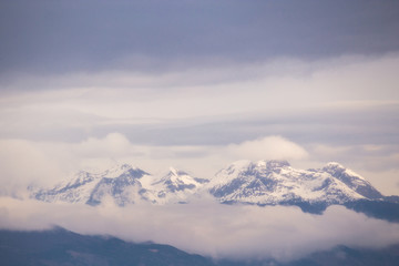 Snowy mountains emerging from the clouds