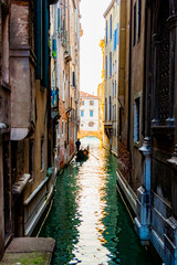 Silhouette of a lonely sad gondolier in a gondola without passengers in a narrow side channel in Venice, Italy. No people because of quarantine Covid-19
