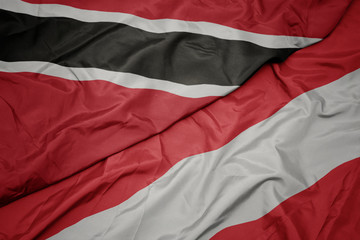 waving colorful flag of austria and national flag of trinidad and tobago.