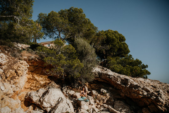 Frau die draußen am Meer auf Mallorca Yoga praktiziert 