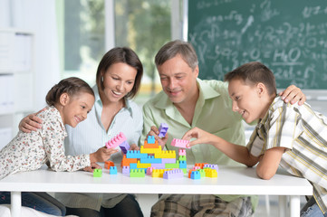 Parents and children playing with colorful plastic blocks at classroom