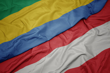 waving colorful flag of austria and national flag of gabon.