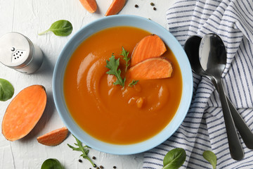 Sweet potato cream soup on white background, top view