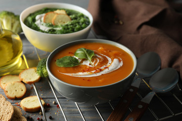 Sweet potato and broccoli cream soups on wooden background, close up