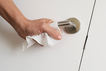 man opening a door using a disinfecting wipe.