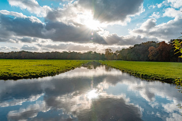 Fototapeta premium beautiful landscape in hdr, clouds, sun, reflections, fresh water, blue sky, grass meadow