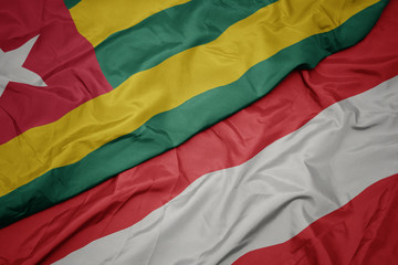 waving colorful flag of austria and national flag of togo.