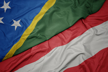 waving colorful flag of austria and national flag of Solomon Islands .