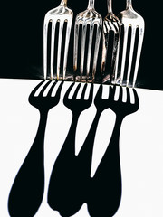 Forks dropping shadows on white