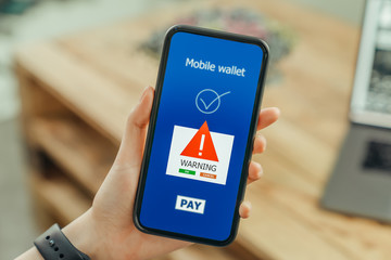 woman hands using smartphone and login mobile banking online with show a warning screen of malware...