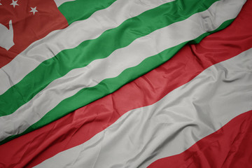 waving colorful flag of austria and national flag of abkhazia.