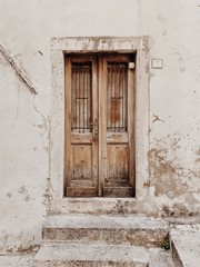 Fototapeta na wymiar Croatia, 2019. An old vintage beige wooden door. Traditional European architecture. Travel minimal concept.