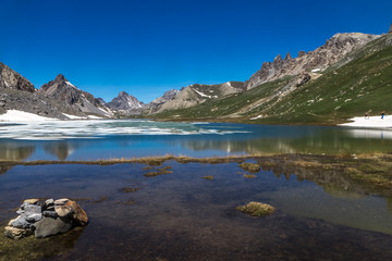 Paysage de la Haute Ubaye au printemps avec un lac en cours de dégel ; vallon de l' Orrenaye ,...